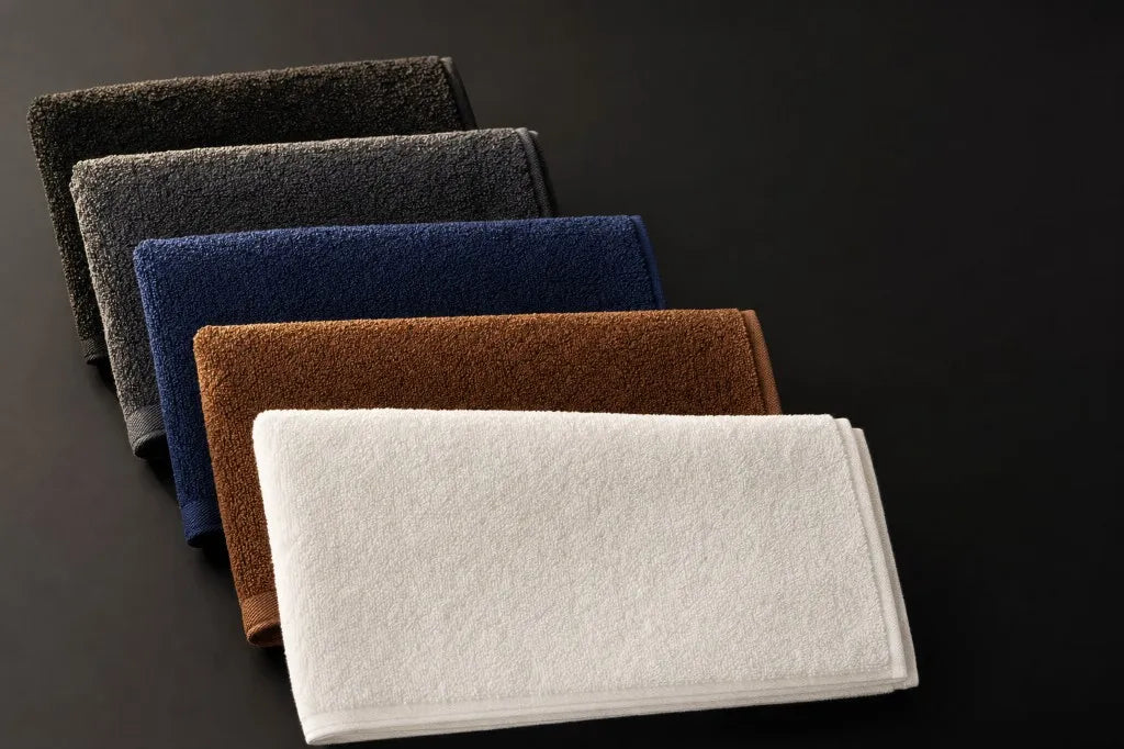 Bleach-proof salon towels in five colours fanned out on dark background